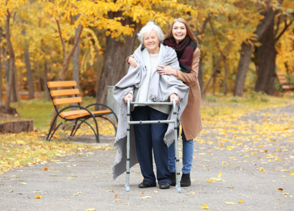 caregiver and senior woman walking outside